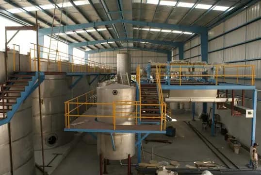 Interior de planta tequilera con tanques y pasarelas