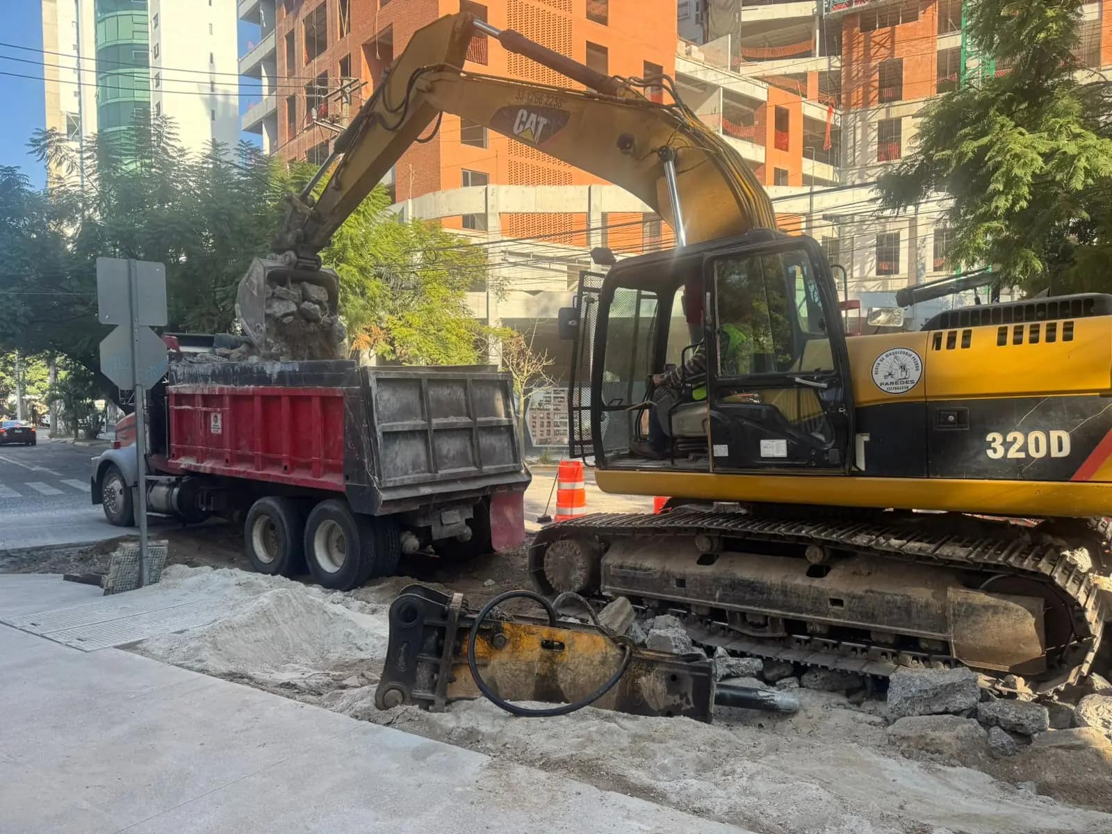 Excavadora CAT 320D y camión de volteo en calle de Providencia