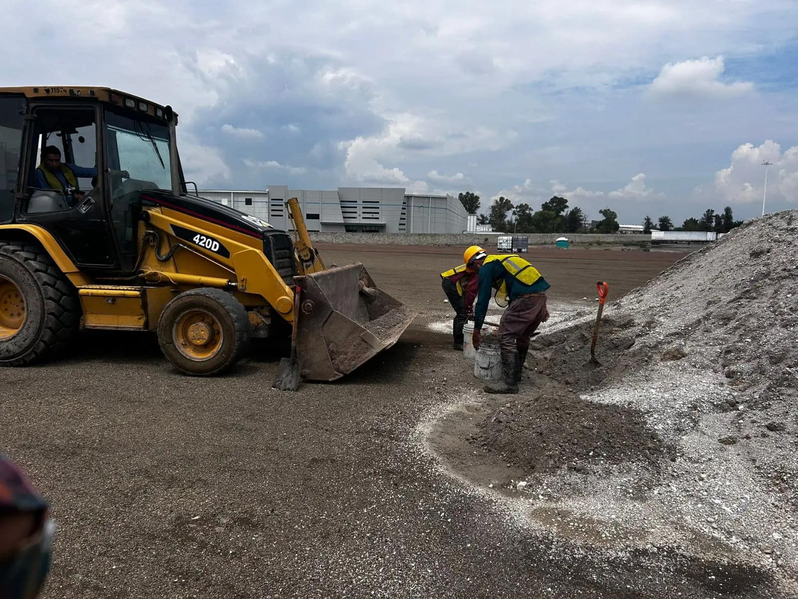 Retroexcavadora con cuadrilla en terracerías