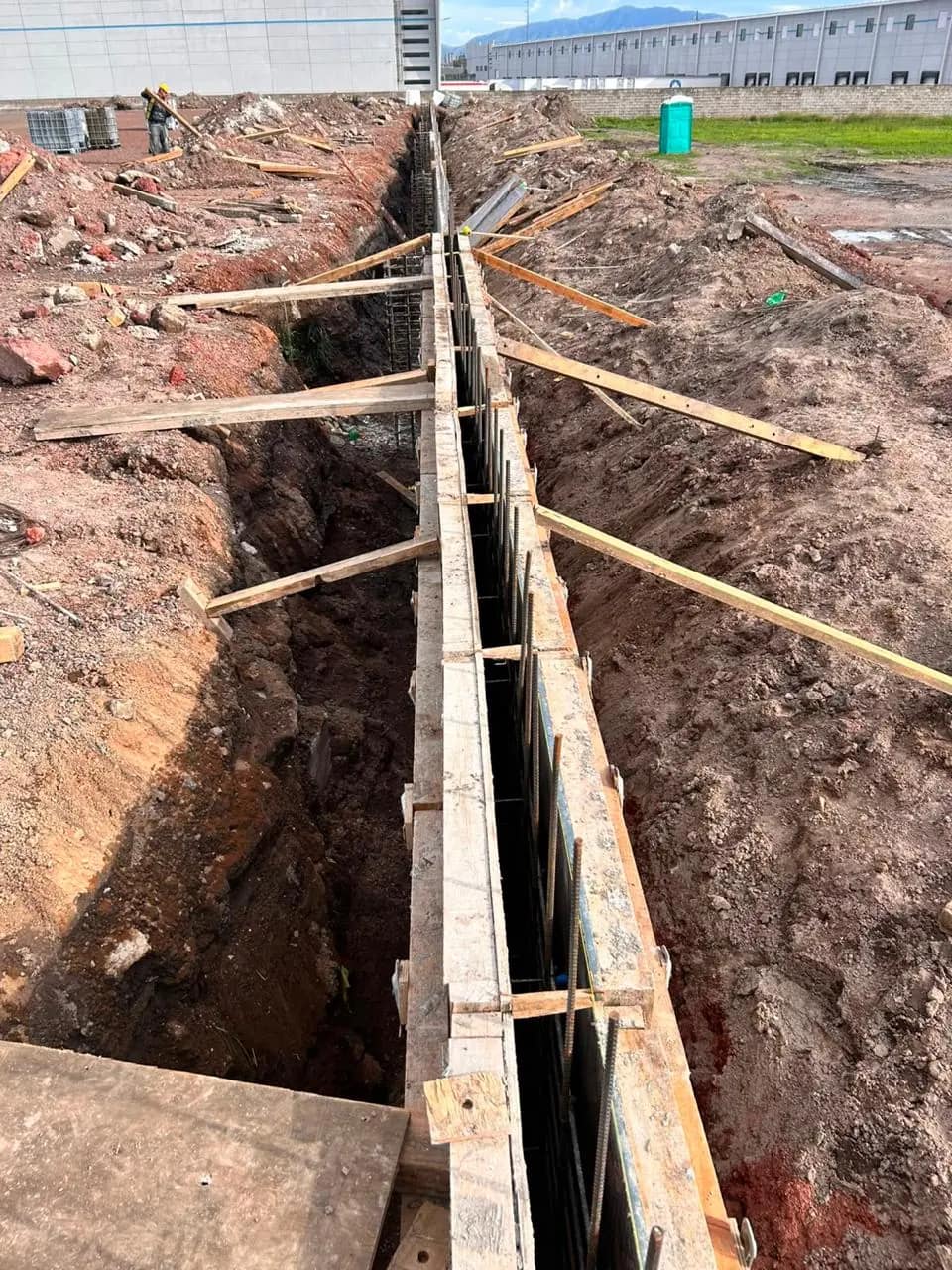 Foundation formwork with a warehouse in the background