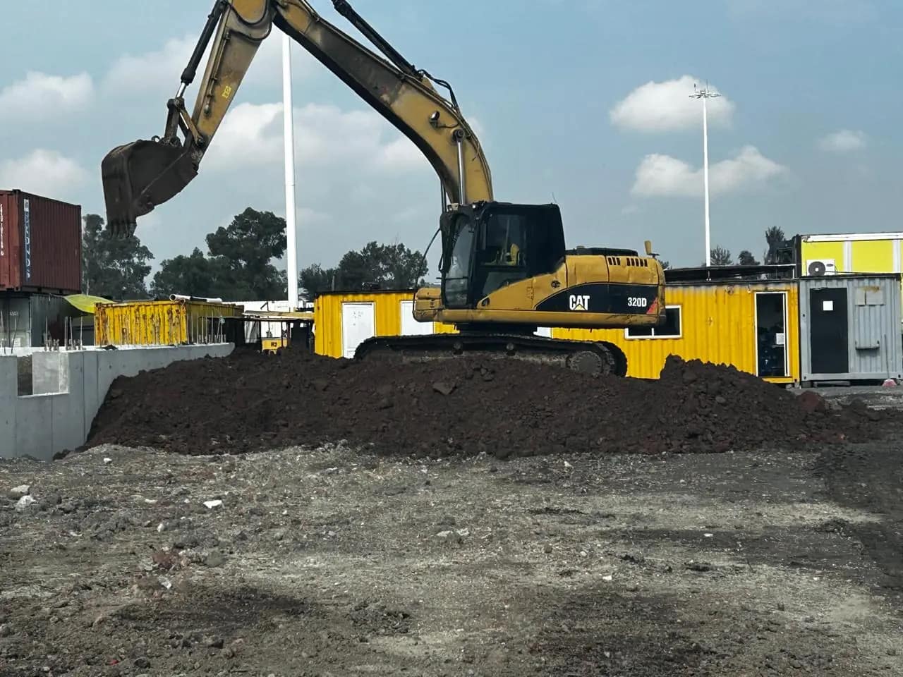 Excavadora cargando camión de volteo en parque industrial