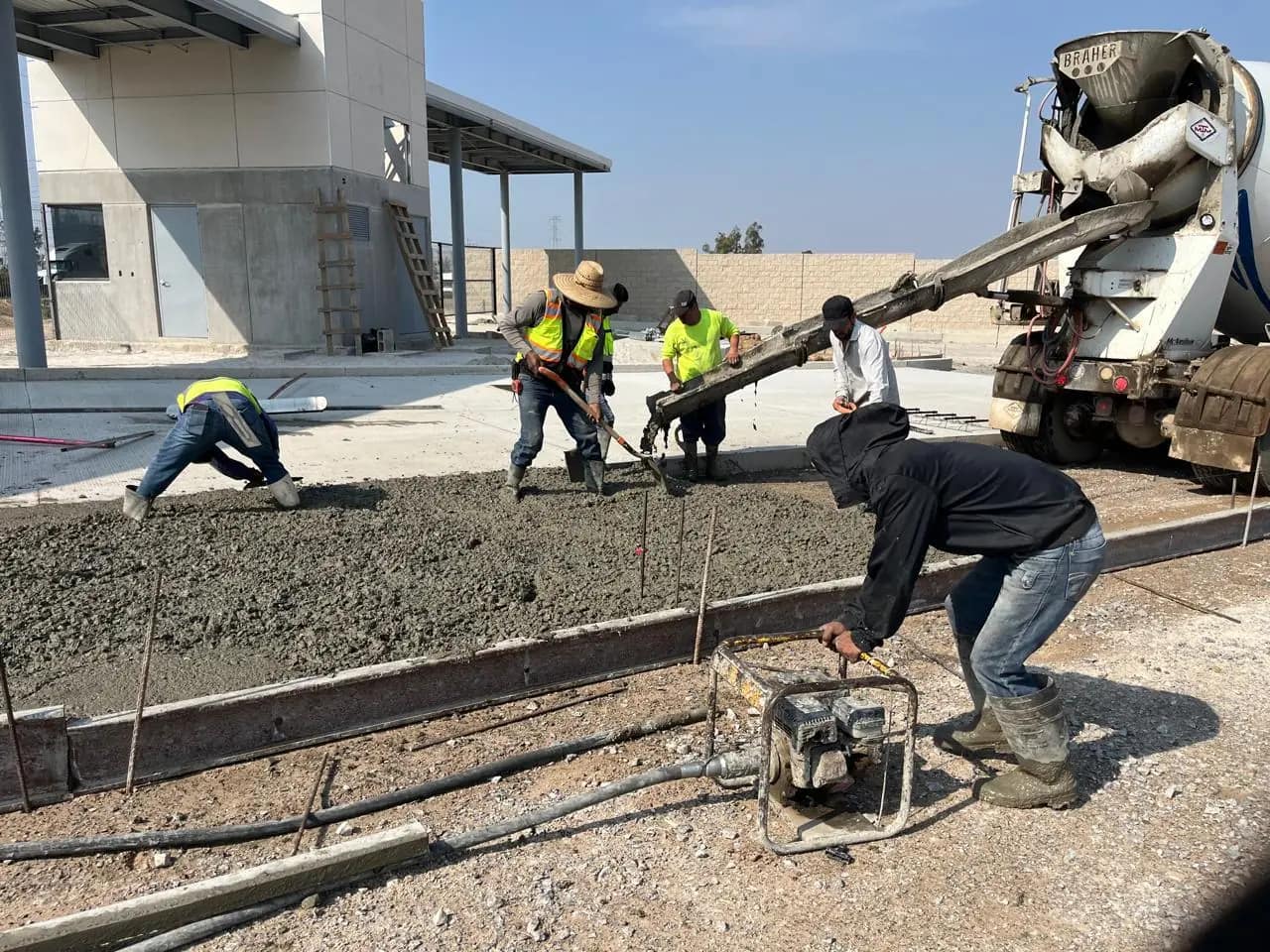 Cuadrilla colando concreto desde olla revolvedora en una plataforma industrial