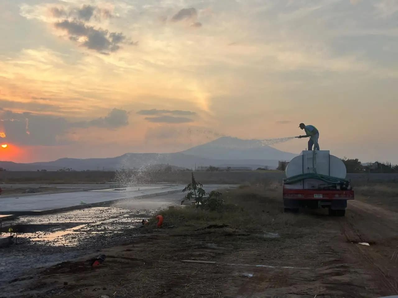 Plataforma de terracerías al atardecer con camión cisterna