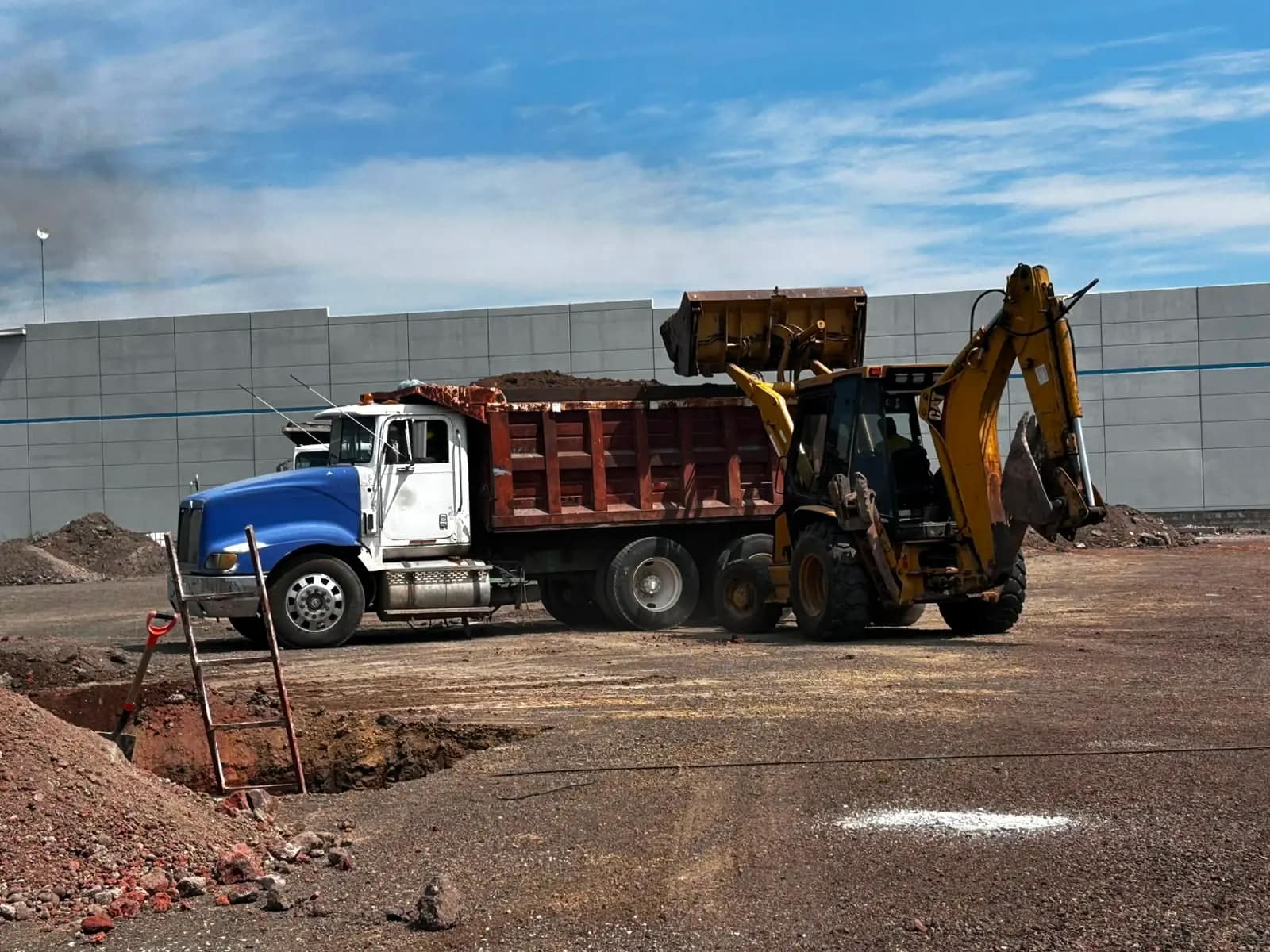 Volteo y retroexcavadora en acarreo de material