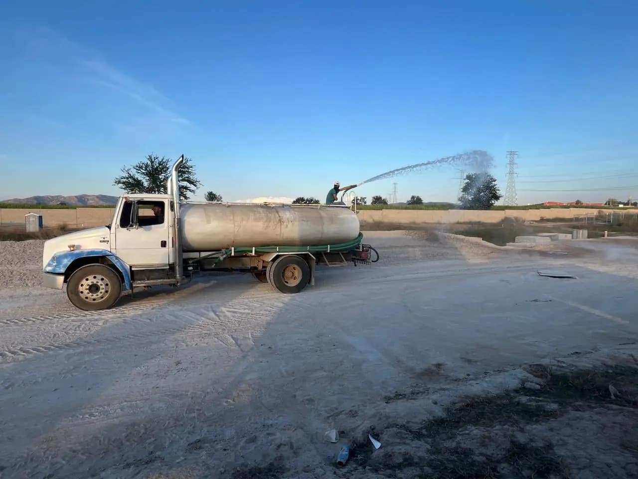 Pipa de agua humectando la plataforma antes de compactar