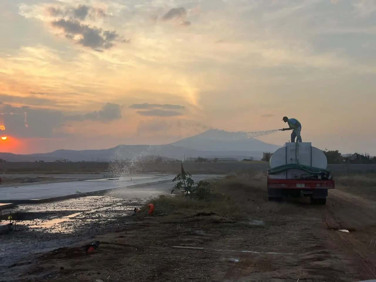 Plataforma de terracerías al atardecer con camión cisterna