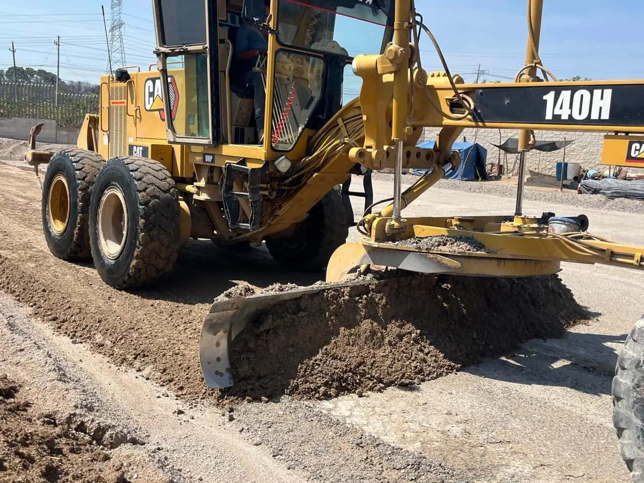 Motoconformadora CAT 140H nivelando una plataforma industrial