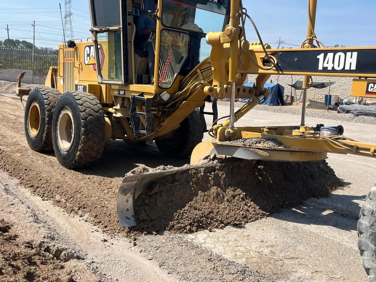 Motoconformadora CAT 140H nivelando una plataforma industrial